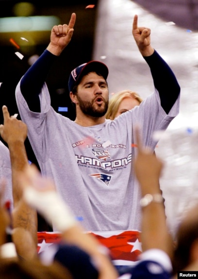 FILE - In this Feb. 3, 2002, file photo, New England Patriots players reach  out to touch the Vince Lombardi Trophy after the Patriots defeated the St.  Louis Rams 20-17 to win