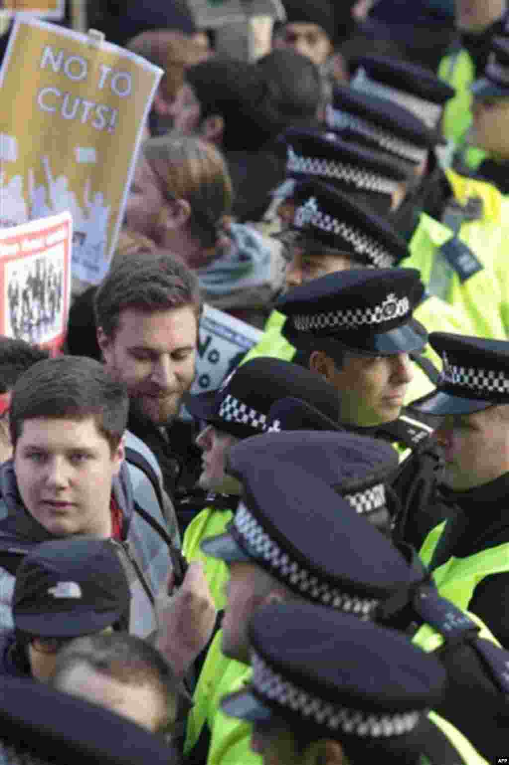Protesters face the police as thousands of students protest against tuition fees at Whitehall in London, Wednesday, Nov. 24, 2010. Several thousand students protested against government plans to triple tuition fees, two weeks after a similar demonstration