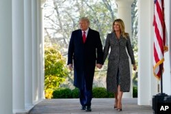 President Donald Trump and first lady Melania Trump walk out of the Oval Office and towards the Rose Garden of the White House, Tuesday, Nov. 24, 2020, in Washington, to pardon Corn, the national Thanksgiving turkey. (AP Photo/Susan Walsh)