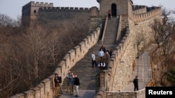 Visitors walk near a section of the Great Wall of China.