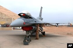 FILE - An Iraqi pilot checks a U.S.- made Iraqi Air Force F-16 fighter jet at the Balad Air Base, 45 miles north of Baghdad, Feb. 13, 2018.