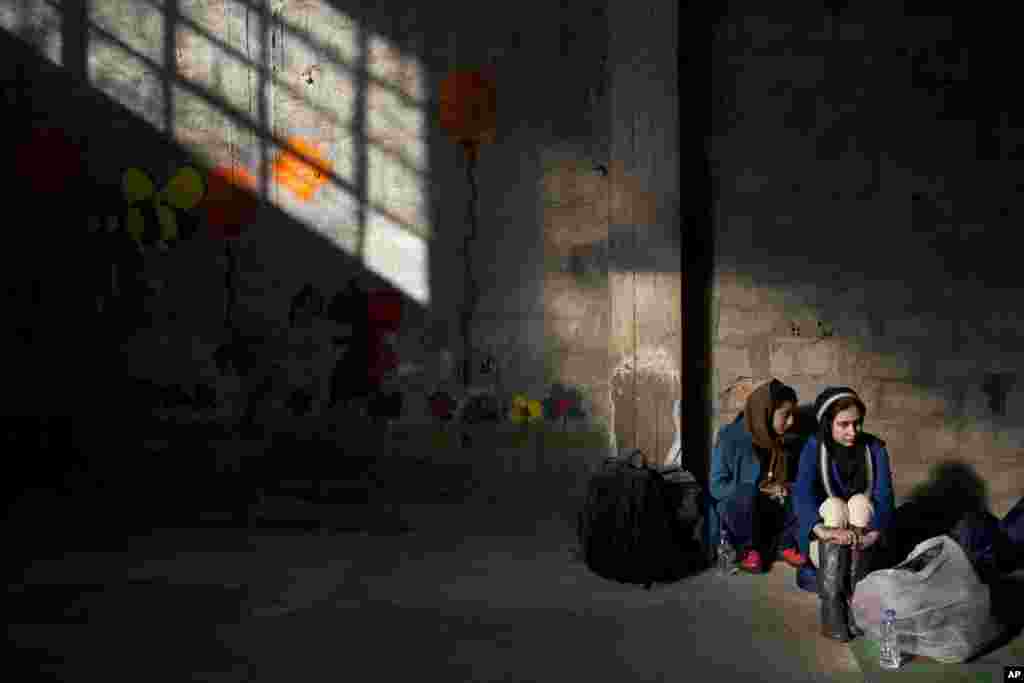 Two Afghan young women wait to be registered in the Tabakika registration center. Thousand of refugees and migrants continue to reach Greece's shores despite the winter weather.