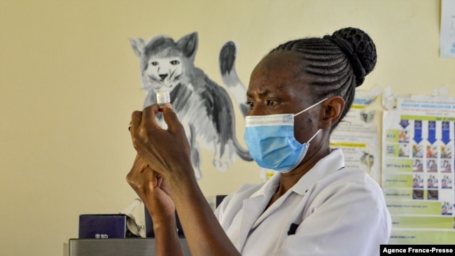 A health worker prepares a malaria vaccination for a child in Yala, Kenya, on Oct. 7, 2021.