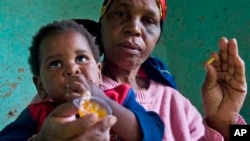 HIV positive child, Gift is given some jam prior to her ARV medication by a carer Tuesday Nov. 30, 2010 near Durban South Africa. (AP Photo/John Robinson)