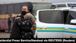 A Ukrainian citizen embraces a relative after the exchange of prisoners of war between Ukraine and the separatist republics near the Mayorsk crossing point in Donetsk region