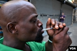 A man smokes a mixture of heroin and cocaine outside a train station in the Kensington neighborhood of Philadelphia, Aug 17, 2017.