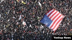 18일 서울광장 인근에서 열린 박근혜 대통령 탄핵 반대 집회 참가자들이 대형 성조기를 펼쳐들고 있다. 