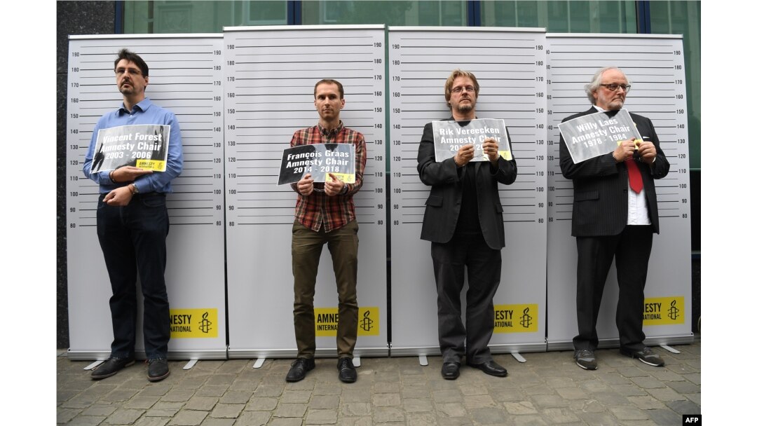 FILE - Former and current heads of Amnesty International in Belgium, (L-R) Vincent Forest, Francois Graas, Rik Vereecken and Willy Laes, stage a mock arrest in front of the Turkish embassy to protest against the detention of Taner Kilic, head of Amnesty I
