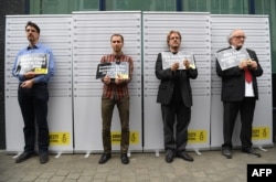 FILE - Former and current heads of Amnesty International in Belgium, (L-R) Vincent Forest, Francois Graas, Rik Vereecken and Willy Laes, stage a mock arrest in front of the Turkish embassy to protest against the detention of Taner Kilic, head of Amnesty I
