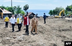 Presiden Joko Widodo (tengah) sedang memeriksa kerusakan di Pulau Lembata menyusul hujan lebat yang dipicu oleh Badai Tropis Seroja, 9 April 2021. (Istana Kepresidenan Indonesia/AFP)