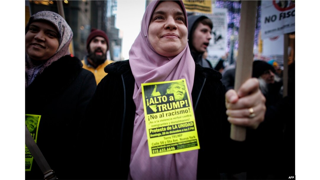FILE - A Muslim woman holds a poster during a protest against Donald Trump in New York, Dec. 20, 2015.