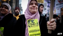 Seorang perempuan Muslim ikut serta dalam aksi protes terhadap Donald Trump di New York, Desember 2015. (AFP/Kena Betancur)