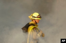 Un bombero de California trabaja en uno de los incendios en una colina de Oakmont, en Santa Rosa. Oct. 12, 2017.