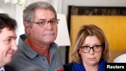 Pascal Fauret (C), one of the two French pilots who had been in the Dominican Republic awaiting a court appeal of their conviction for drug trafficking and now back in France, attends a news conference with his wife Sabine Fauret (R) at his lawyer's office in Paris, Oct. 27, 2015.