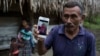 Domingo Caal Chub, 61, holds a smartphone displaying a photo of his granddaughter, Jakelin Caal Maquin, in Raxruha, Guatemala, Dec. 15, 2018. The 7-year-old girl died in a Texas hospital, two days after being taken into custody by U.S. Border Patrol agent