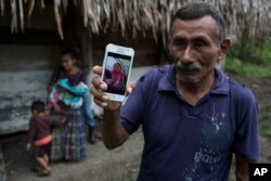 Domingo Caal Chub, 61, holds a smartphone displaying a photo of his granddaughter, Jakelin Caal Maquin, in Raxruha, Guatemala, Dec. 15, 2018. The 7-year-old girl died in a Texas hospital, two days after being taken into custody by U.S. Border Patrol agents in a remote stretch of New Mexico desert.