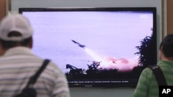People watch a TV news program showing the missile launch conducted by North Korea, at Seoul Railway Station in Seoul, South Korea, June 29, 2014. 