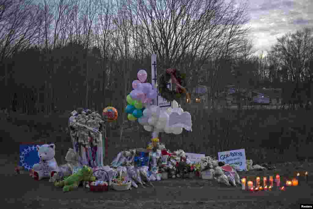 A memorial is seen along the road to Sandy Hook Elementary School a day after a mass shooting in Newtown, Connecticut, December 15, 2012. 