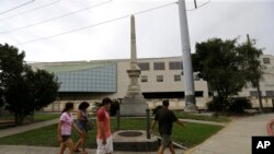  FILE - People walk past the Liberty Place monument in downtown New Orleans, Sept. 2, 2015. In December, the New Orleans City Council voted to remove the obelisk commemorating the Battle of Liberty Place, as well as other Confederate-related statutes.