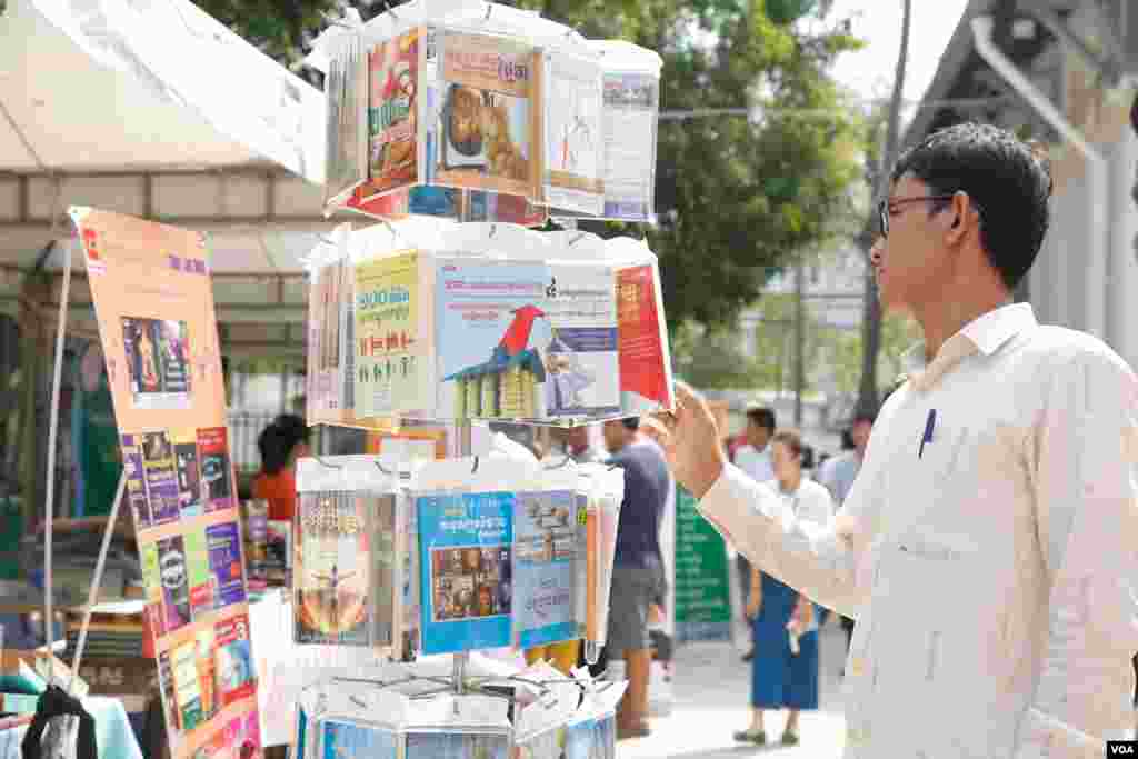 ប្រជាជនកម្ពុជា ទស្សនា និងជាវសៀវភៅ តាមស្តង់តាំងពិពណ៌និងលក់សៀវភៅ ក្នុងទិវាអំណានជាតិលើកទី២ នៅវិទ្យាស្ថានជាតិអប់រំ​ នាថ្ងៃទី ១១ ខែមីនា ឆ្នាំ ២០១៧។​ (ខាន់ សុគុំមនោ/VOA)