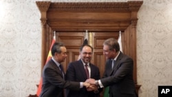 Afghanistan's Minister of Foreign Affairs Salahuddin Rabbani, center, Pakistan's Foreign Minister Shah Mehmood Qureshi, first right, and Chinese Foreign Minister Wang Yi, first left, shake hands after signing the agreement at the presidential palace in Kabul, Dec. 15, 2018.