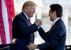 President Donald Trump welcomes Japanese Prime Minister Shinzo Abe outside the West Wing of the White House in Washington, Feb. 10, 2017.