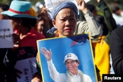 FILE - Supporters of Kem Sokha, leader of the now dissolved Cambodia National Rescue Party (CNRP), stand outside the court during a hearing for the jailed opposition leader in Phnom Penh, Cambodia, Sept. 26, 2017.