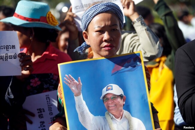 FILE - Supporters of Kem Sokha, leader of the now dissolved Cambodia National Rescue Party (CNRP), stand outside the court during a hearing for the jailed opposition leader in Phnom Penh, Cambodia, Sept. 26, 2017.