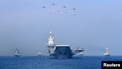 2018年4月12日，中國海軍在南中國海軍演展示軍艦與戰機。