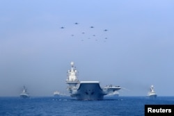 Warships and fighter jets of Chinese People's Liberation Army (PLA) Navy take part in a military display in the South China Sea April 12, 2018. Picture taken April 12, 2018. REUTERS/Stringer