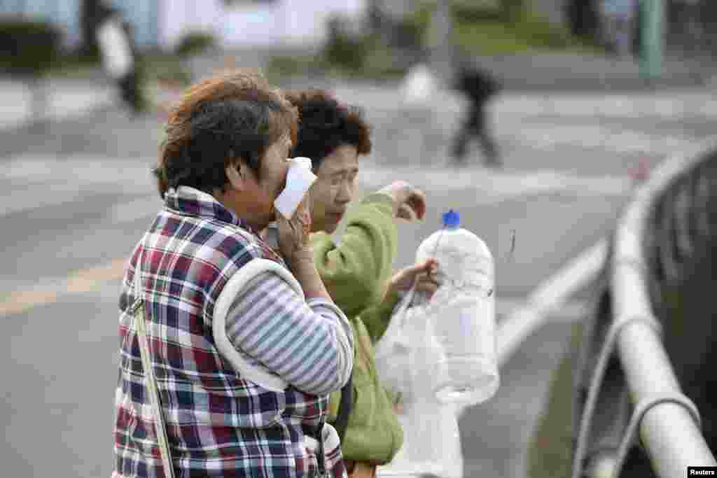A woman cries as she looks at her collapsed house caused by an earthquake in Mashiki town, Kumamoto prefecture, southern Japan, in this photo taken by Kyodo, April 17, 2016.