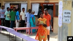 A Sri Lankan ethnic Tamil couple leaves after casting their vote as others line up to vote at a polling station during the northern provincial council election in Jaffna, Sept. 21, 2013.