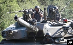 South Korean army soldiers ride a K-1 tank during the annual exercise in Paju, South Korea, near the border with North Korea, Aug. 22, 2016.