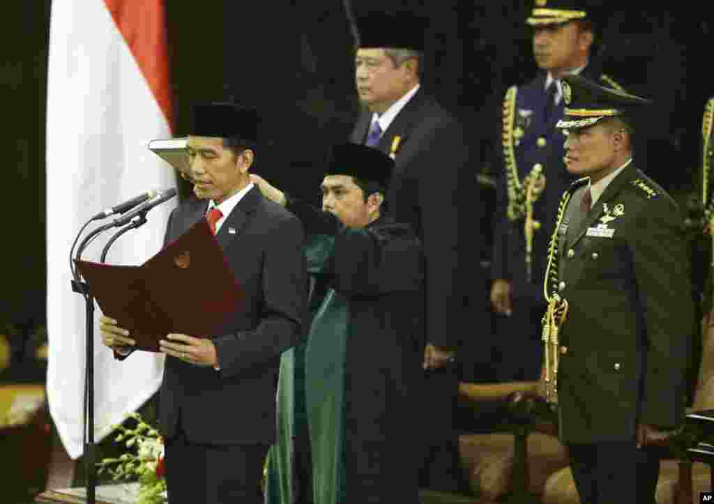 Presiden Indonesia ke tujuh, Joko Widodo, membacakan sumpah di gedung DPR/MPR RI, Jakarta (20/10). (AP/Dita Alangkara) 