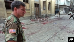 FILE - Lt. Col. Charles Vuckovic Defense Attache of the U.S. embassy in Sarajevo visits the location of the mortar impact near a market place in downtown Sarajevo, Aug. 28, 1995.