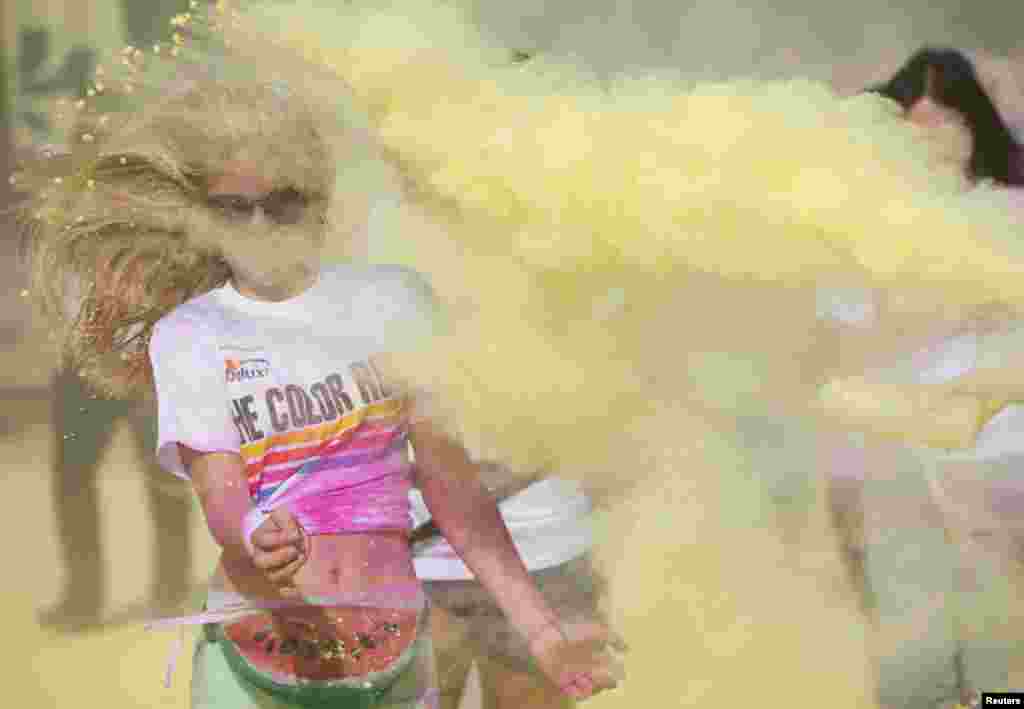 A woman is covered in paint as she takes part in a Color Run event in east London.