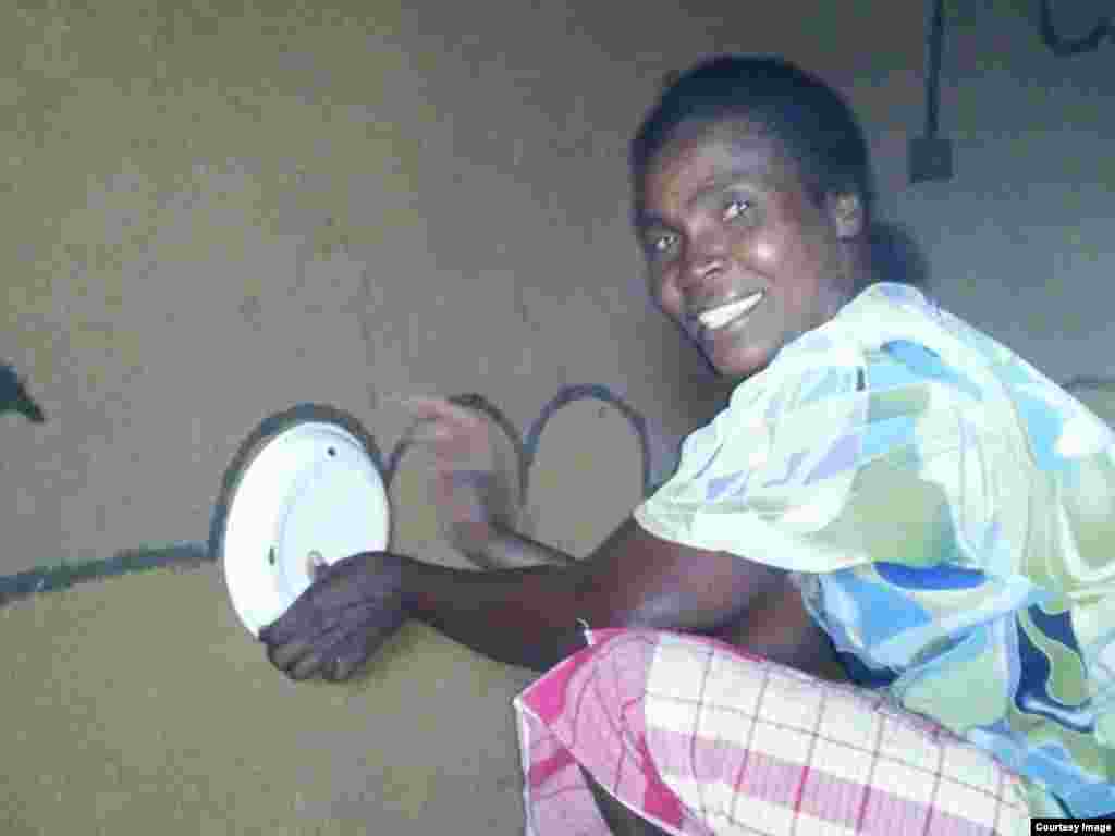 A Matobo woman seen at work, decorating her hamlet using mud sourced locally.