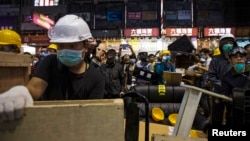 Pro-democracy protesters set up a new road block during a confrontation with riot police at Mong Kok shopping district in Hong Kong, Nov. 25,2014.