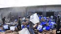 Guinean soldiers remove boxes filled with electoral materials from a warehouse on fire in a military camp in Conakry, 16 Sep 2010