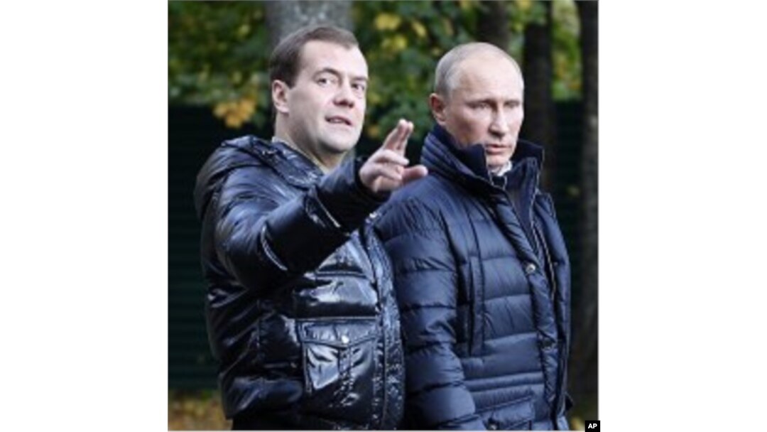 Russian President Dmitry Medvedev, left, gestures as he and Prime Minister Vladimir Putin walk at the presidential residence in Zavidovo, about 90 miles (150 kilometers) north of Moscow, Russia (File Photo).