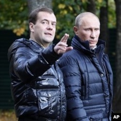 Russian President Dmitry Medvedev, left, gestures as he and Prime Minister Vladimir Putin walk at the presidential residence in Zavidovo, about 90 miles (150 kilometers) north of Moscow, Russia (File Photo).