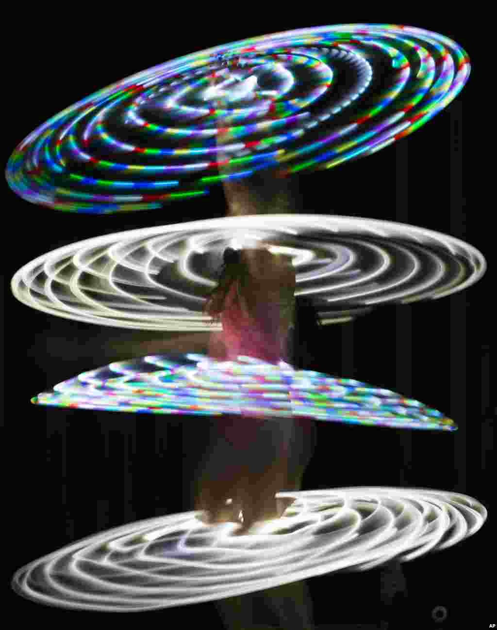 Canadian hooper Rebecca Halls performs with illuminated hula hoops at the Hula Hoop Festival Hoopurbia 2014 in Berlin, Germany.