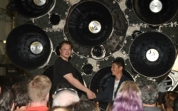 FILE - SpaceX CEO Elon Musk (L) shakes hands with Japanese billionaire Yusaku Maezawa during a press conference about being the first SpaceX private passenger to circle the moon aboard SpaceX’s BFR launch vehicle, in Hawthorne, California September 17, 2020