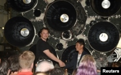 FILE - SpaceX CEO Elon Musk (L) shakes hands with Japanese billionaire Yusaku Maezawa during a press conference about being the first SpaceX private passenger to circle the moon aboard SpaceX’s BFR launch vehicle, in Hawthorne, California September 17, 2020