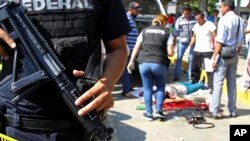 FILE - Police and forensics secure the area where six people were killed, in Acapulco, Mexico, Jan. 4, 2017. 