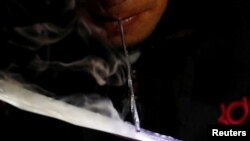 FILE - A drug user inhales "shabu," or methamphetamine, at a drug den in Manila, Philippines.