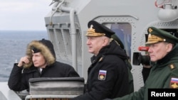 Le président russe Vladimir Poutine (à g.), avec des officiers supérieurs lors des exercices en mer Noire, au large des côtes de la Crimée, le 9 janvier 2020.