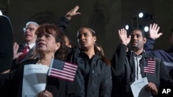 Nuevos ciudadanos de EE.UU. toman el juramento a la bandera en los Archivos Nacionales, en Washington D.C. Dec. 15, 2015.