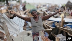 FILE - A woman gestures in front of a demolished house in Otodo-Gbame waterfront in Lagos Nigeria. March 18, 2017. 