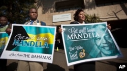 A group of wellwishers hold up get-well placards outside the entrance to the Mediclinic Heart Hospital where former South African President Nelson Mandela is being treated in Pretoria, June 16, 2013. 